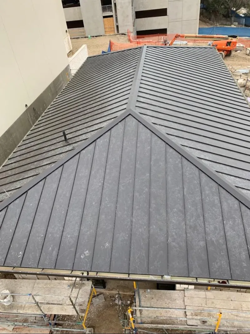 Commercial metal roof construction with crane equipment in Greensburg